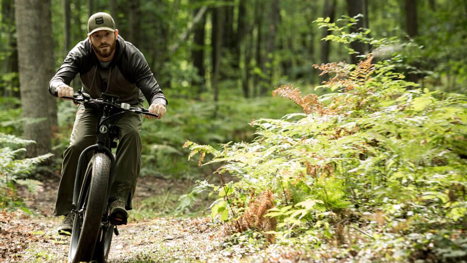 Man riding on Rambo e-bike on trails in the forest