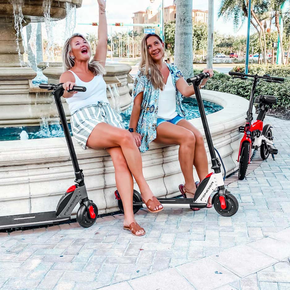 Two ladies on Fender pocketROCKET Folding Electric Bike Red and Fender Bomber Electric Scooters